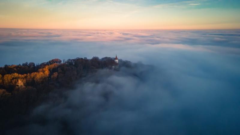 A Kőszegi-hegység ékköve alatt a köd titokzatos fátylát teríti el, mintha a természet egy különleges titkot rejtegetne. Az elbűvölő táj színei és formái még inkább felerősödnek a pára által, amely varázslatos atmoszférát teremt. A sokszínű vidék rejtett s